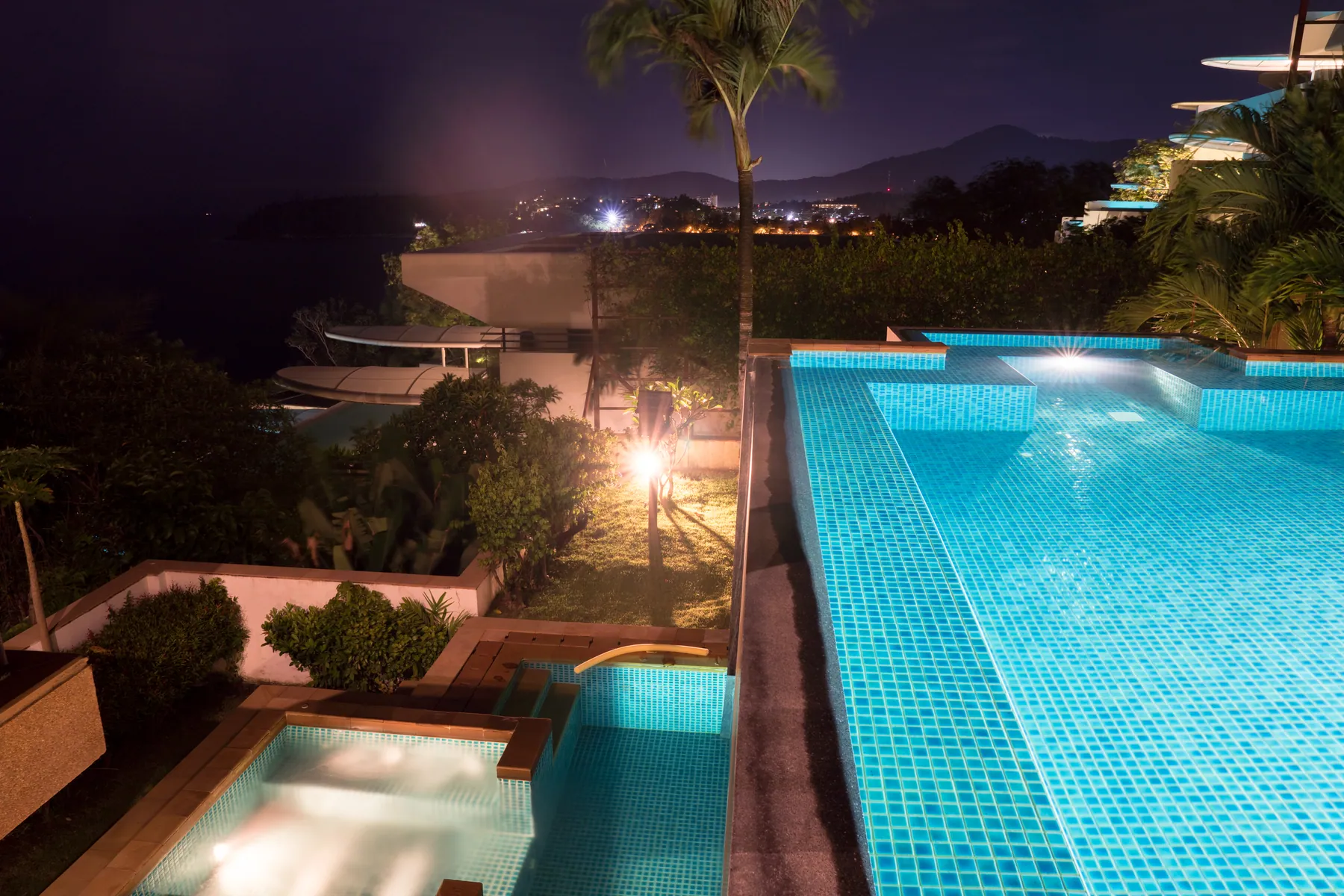 The pool, the lower mini pool and the spa pool lit at night