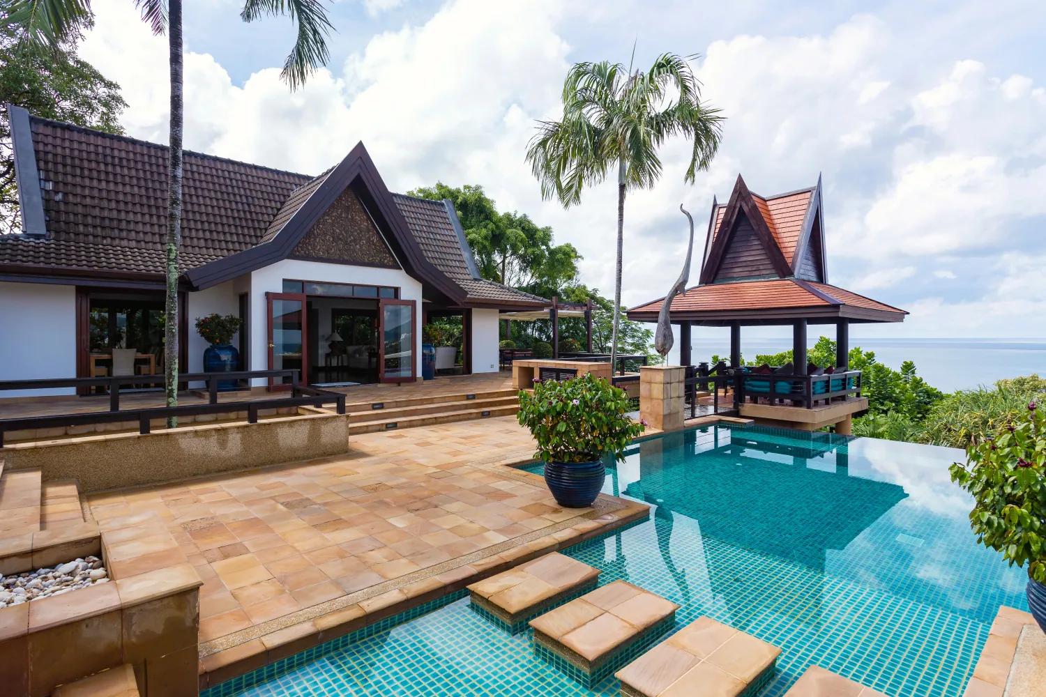 Sandstone stepping stones crossing the aqua mosaic infinity pool